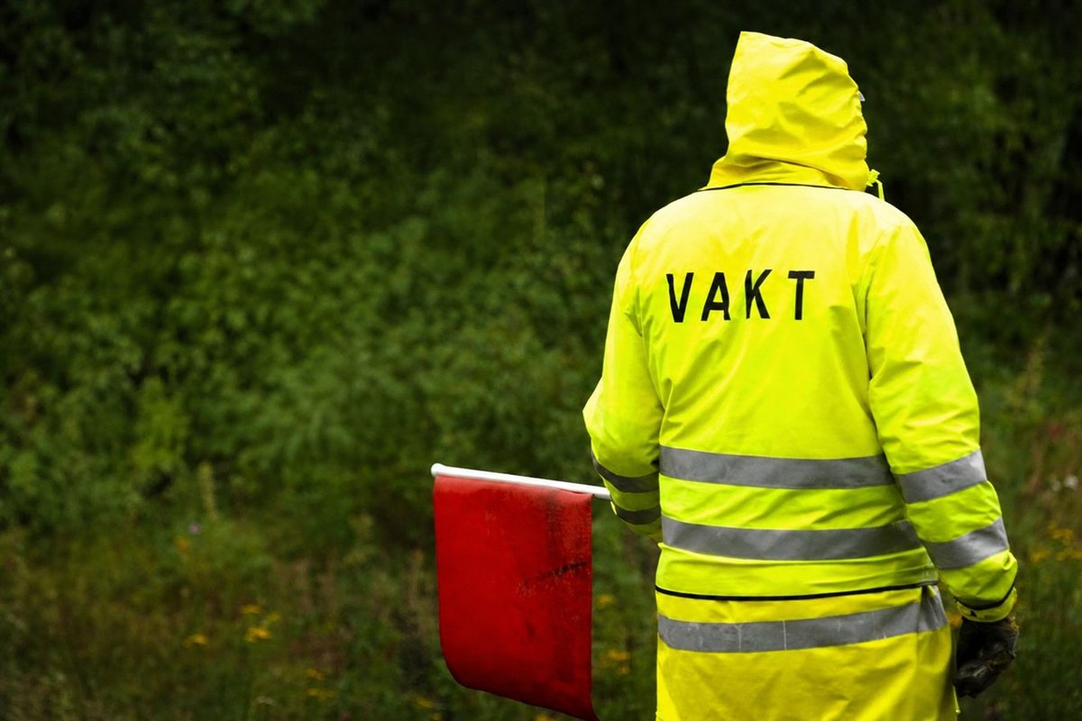 Flaggvakt som dirigerar trafiken vid ett vägarbete i Stockholm